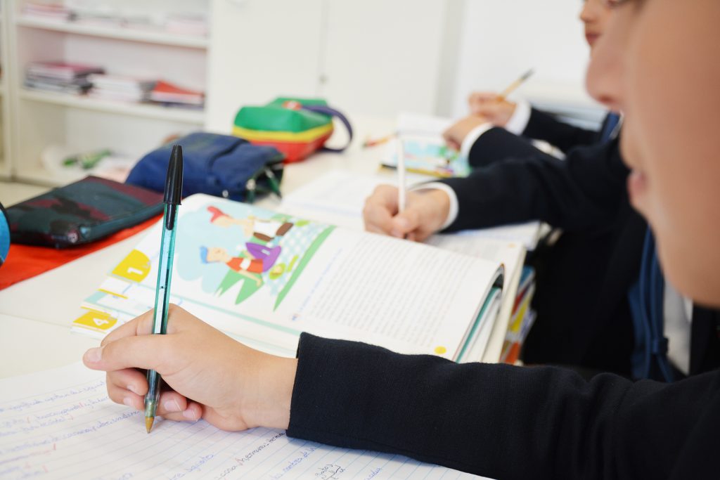 Becas y ayudas del Colegio CEU San Pablo Sevilla. Alumnado en pupitres con material escolar