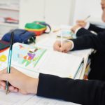 Becas y ayudas del Colegio CEU San Pablo Sevilla. Alumnado en pupitres con material escolar